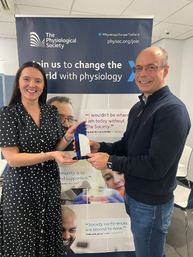 Colleen Deane, R Jean Banister Prize Lecture recipient presented with the trophy from Dr Matthew Lancaster at University of Leeds.